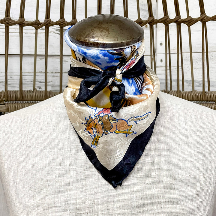 Mannequin head with a colorful scarf draped around its neck against a wicker chair background.