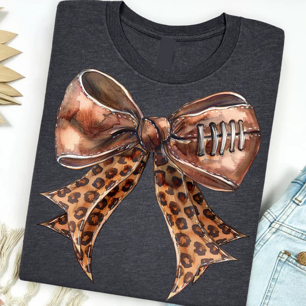 Graphite grey short sleeve tee featuring a football graphic shaped like a bow with leopard print, combining sporty style with playful flair.