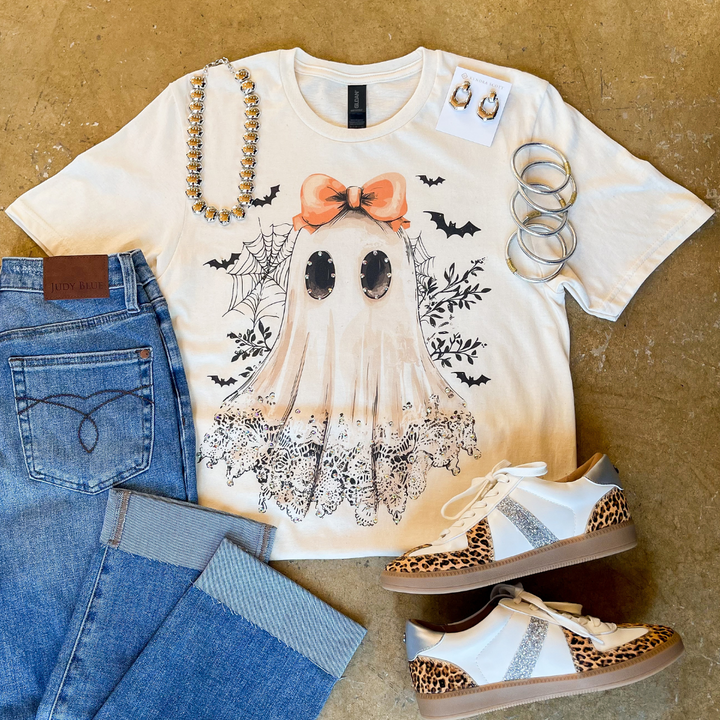 Halloween-themed t-shirt with ghost design, jeans, and sneakers.