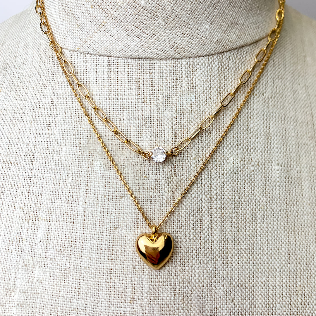 This Lovely Tokens Gold Tone Multi Strand Pendant Necklace is pictured on an ivory mannequin with a white background.