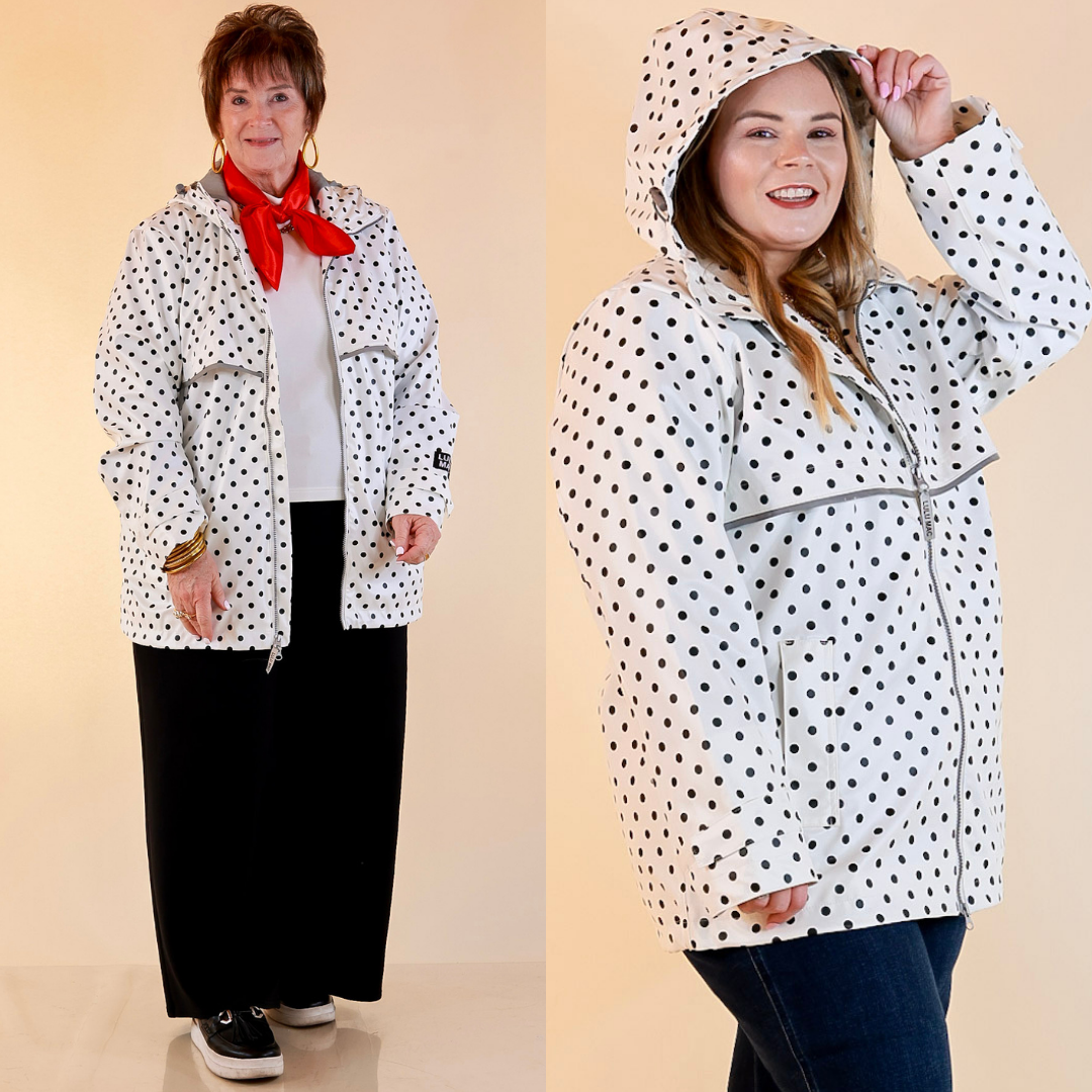 Models are wearing Black Polka Dot Hooded Rain Jacket in Ivory with Jeans against a beige backdrop.