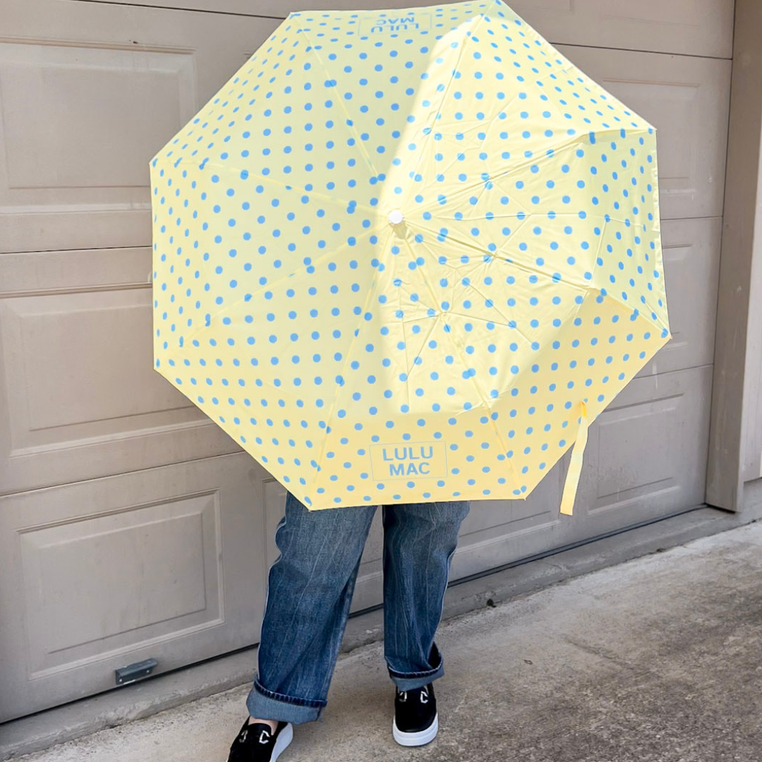 Yellow umbrella with blue polka-dots.