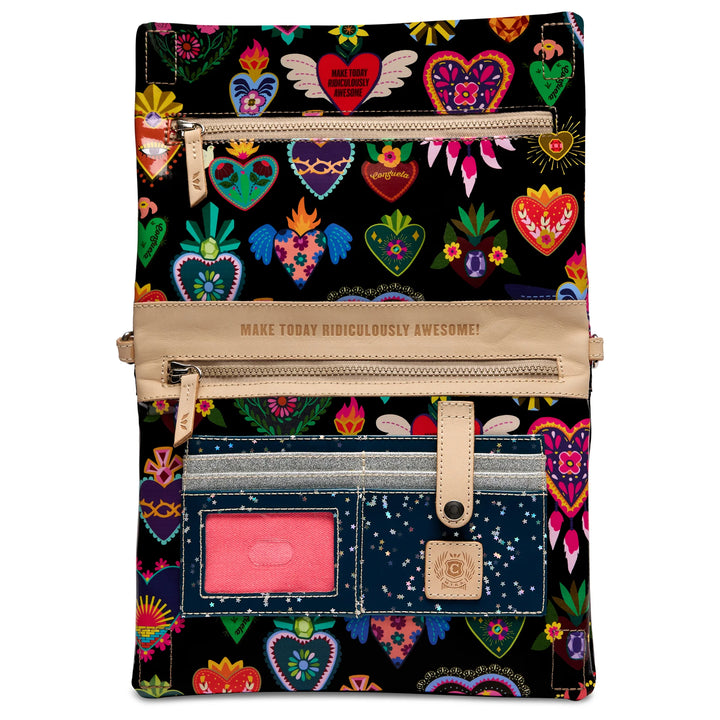 A zip-around tablet sleeve or document pouch with a black background covered in colorful heart motifs and floral patterns. It features beige faux-leather trim, multiple zippered compartments, a pink ID window, and a small branded patch.