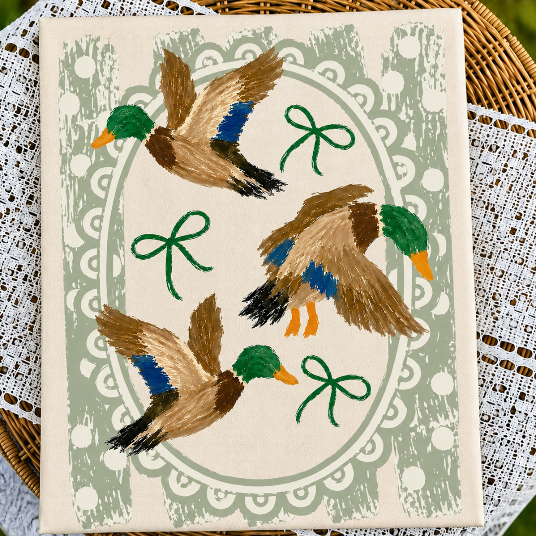 Ivory or brown graphic tee or sweatshirt featuring three painted mallard ducks, green bows, sage polka dots and a scalloped oval frame.