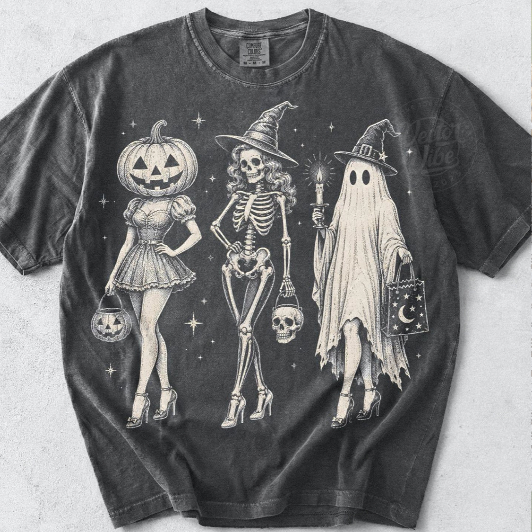 Pepper grey Halloween graphic tee or sweatshirt featuring a vintage-style pumpkin girl, witch skeleton and ghost in heels with spooky trick-or-treat accessories.