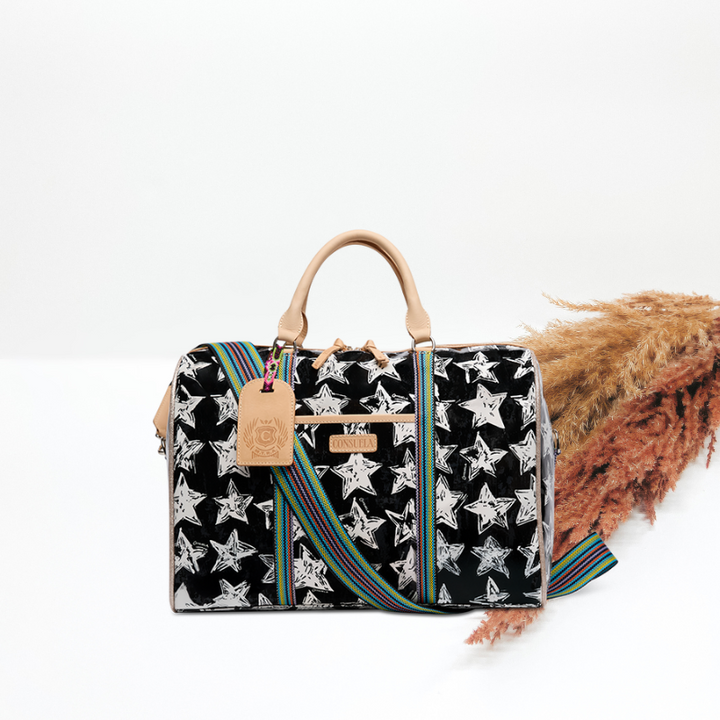 Black handbag with star pattern and colorful strap on a white background