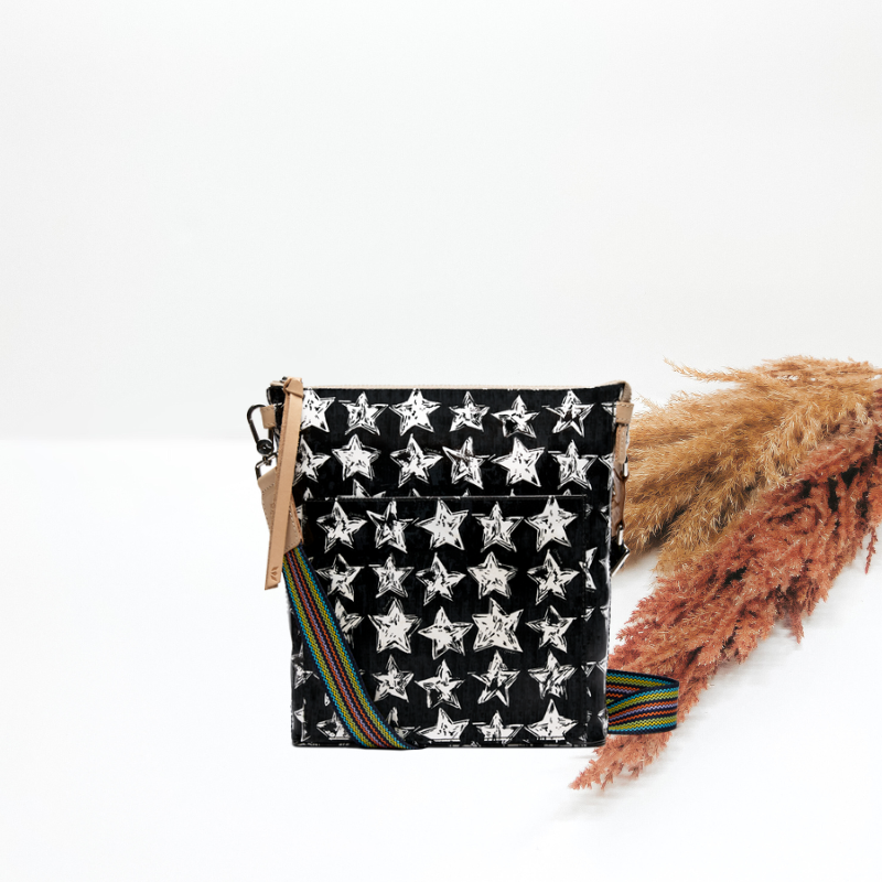 Black bag with white star pattern and colorful strap on a white background