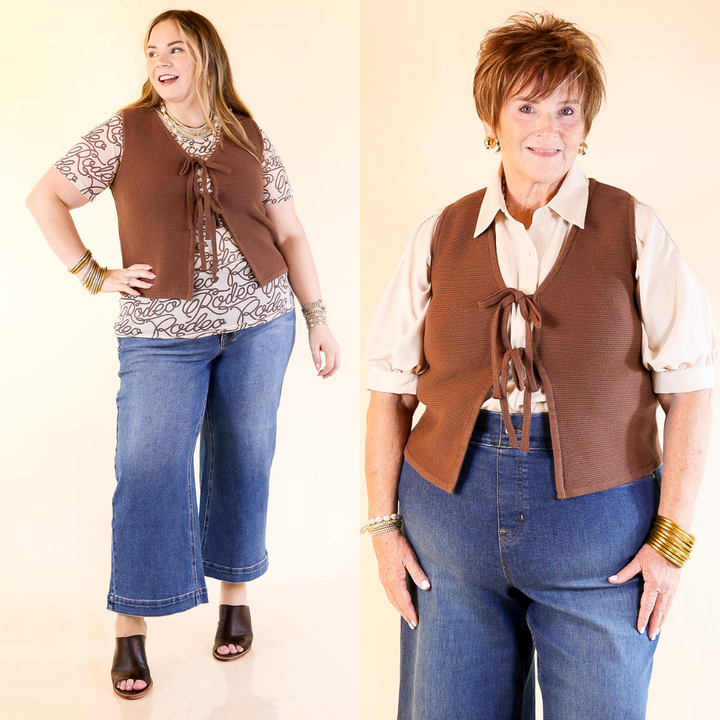 Two women wearing chocolate brown vests over patterned shirts with blue jeans on a beige background