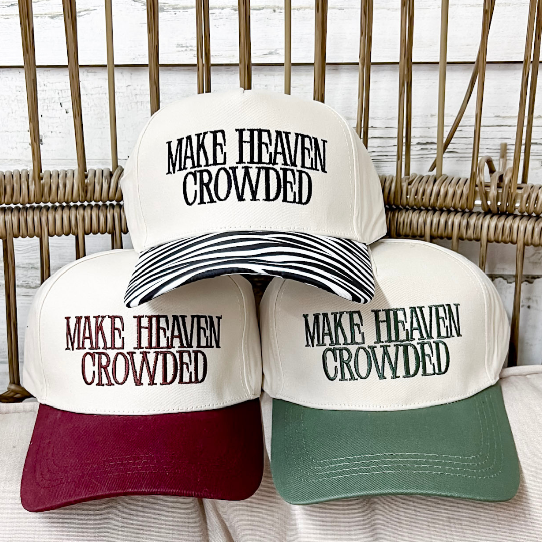 Make Heaven Crowded embroidered two-tone canvas trucker cap available in Forest Green, Raisin, and Zebra with a structured cream crown and adjustable snapback closure.