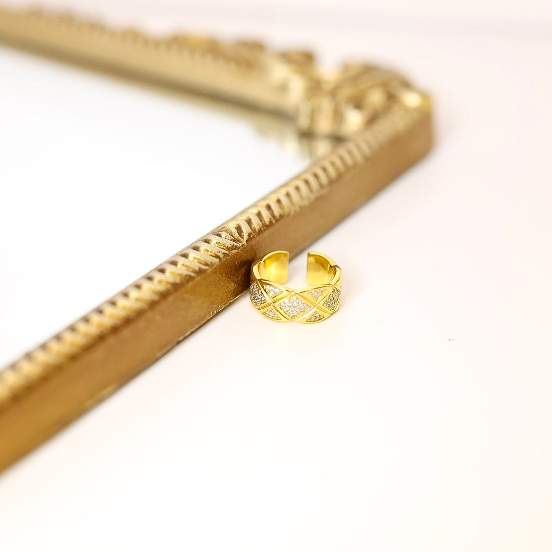 Gold ring on a gold decorative object with a white background