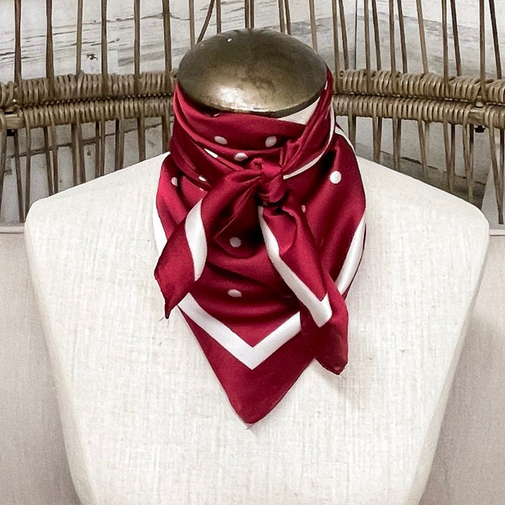 Mannequin wearing a red scarf in a wicker chair with a blurred background