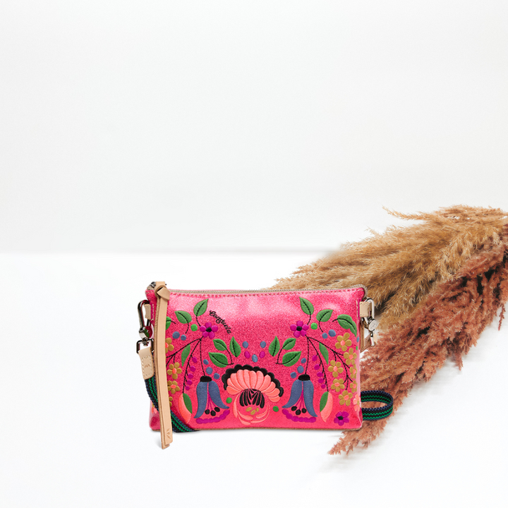 Pink embroidered clutch bag with a strap on a white background