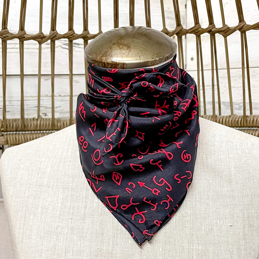 Black bandana with red patterns on a mannequin head against a wicker chair background