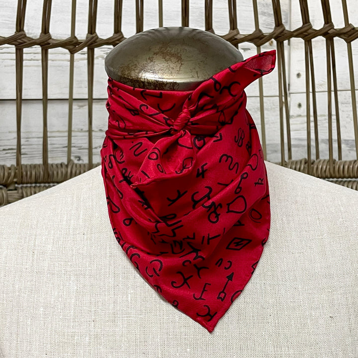 Red bandana with black patterns on a mannequin against a wicker chair background