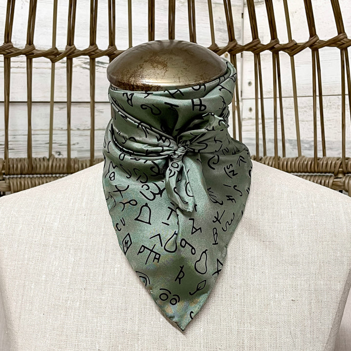 Green patterned scarf on a mannequin bust with a wicker basket background