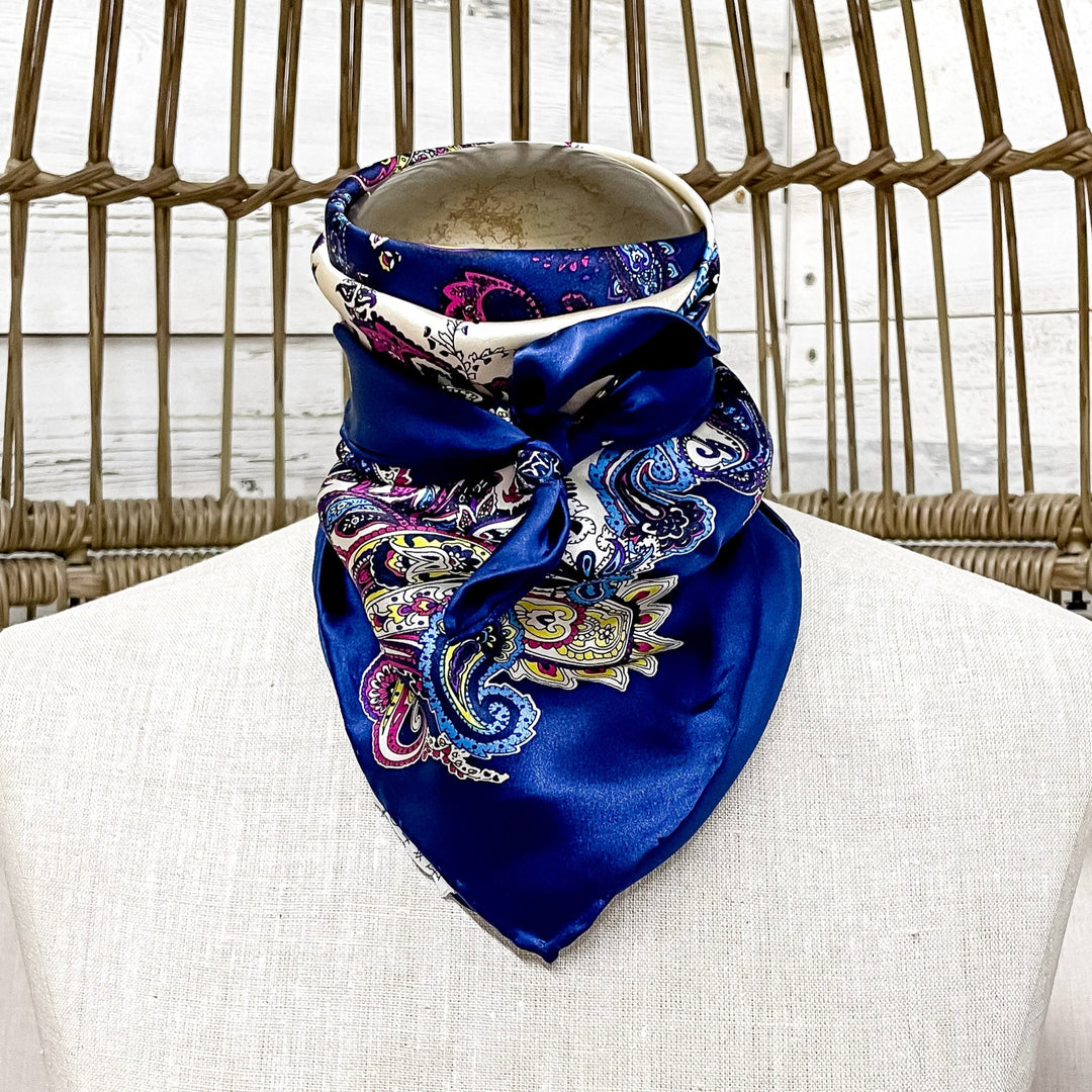 Mannequin wearing a blue patterned scarf against a wicker chair background