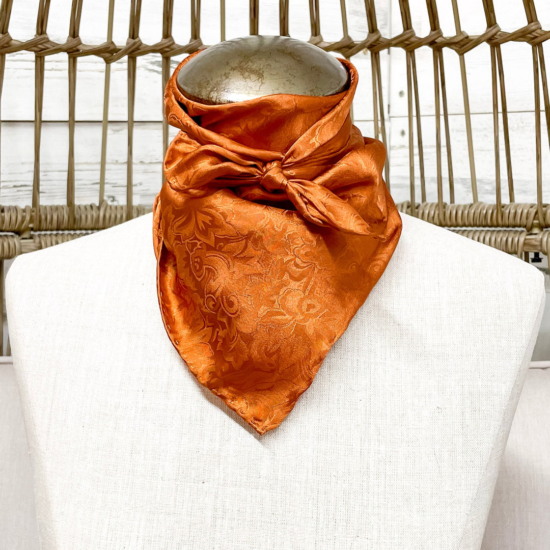 A Copper wild rag tied on a mannequin neck