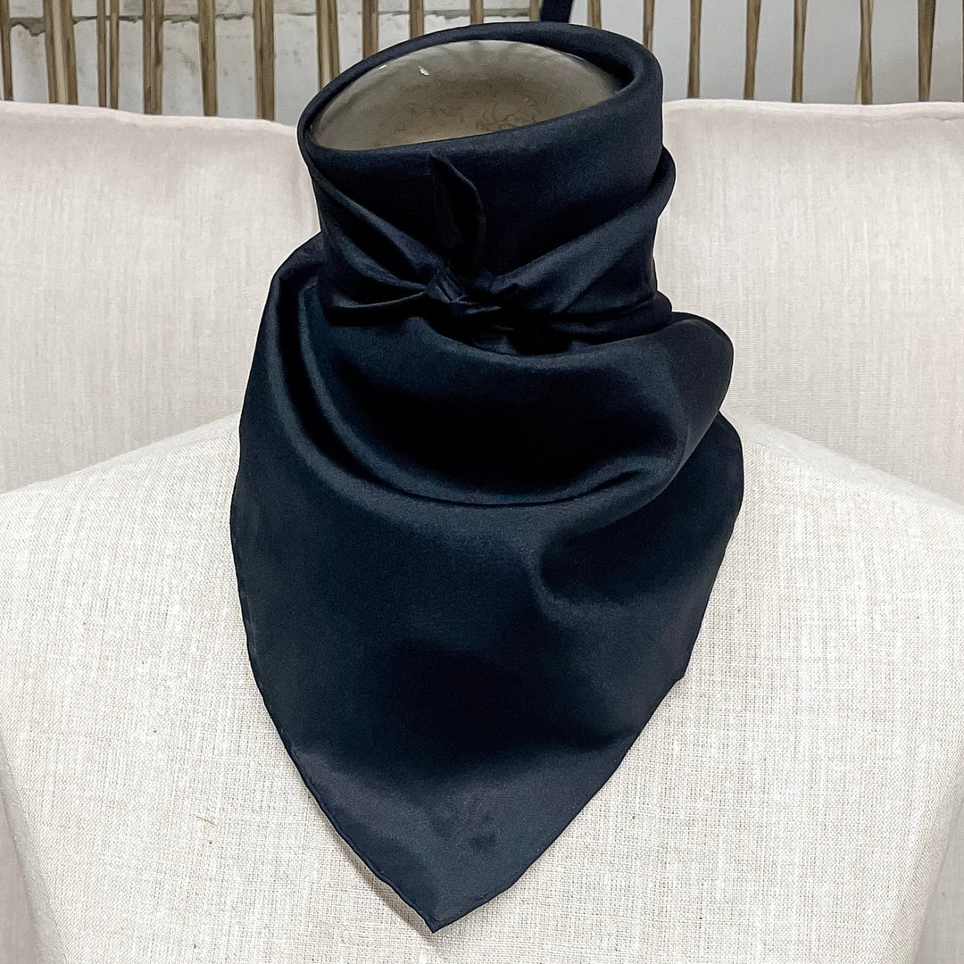 A solid black wild rag in size mini, tied around the neck of a mannequin.
