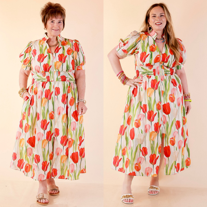 Models are wearing Front Zip Midi Tulip Print Dress with Smocked Waist and Short Sleeves in Cream against a beige backdrop. 