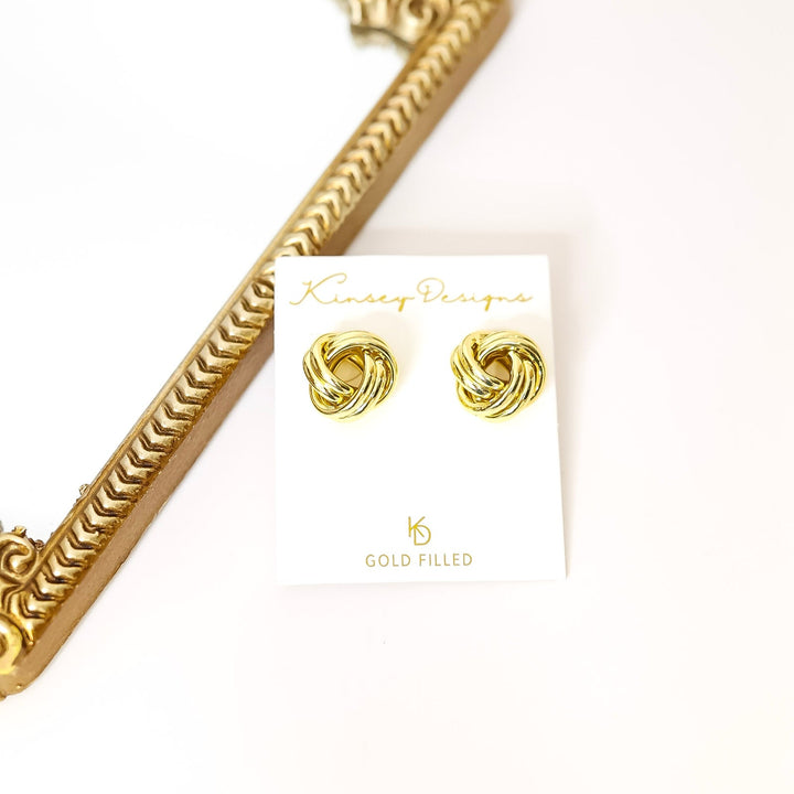 Gold earrings on a white card with kinsey designs branding, against a white background.