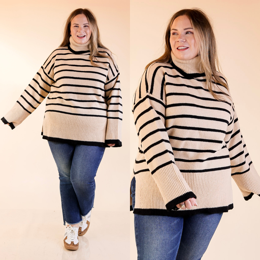 woman is wearing a tan and black striped sweater and jeans on a plain background