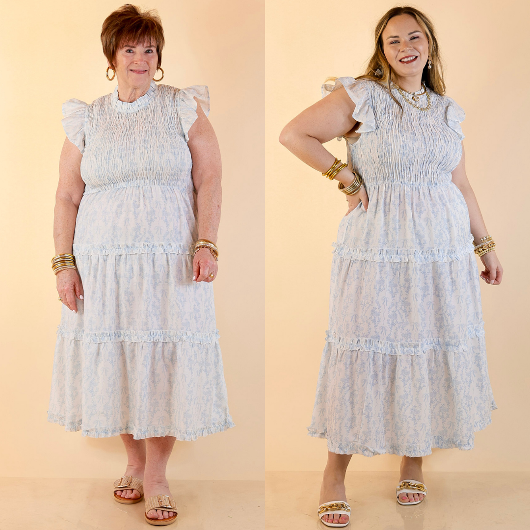 Models are wearing Smocked Toile Print Tiered Midi Dress with Ruffle Sleeves in Blue and white against a beige backdrop. 