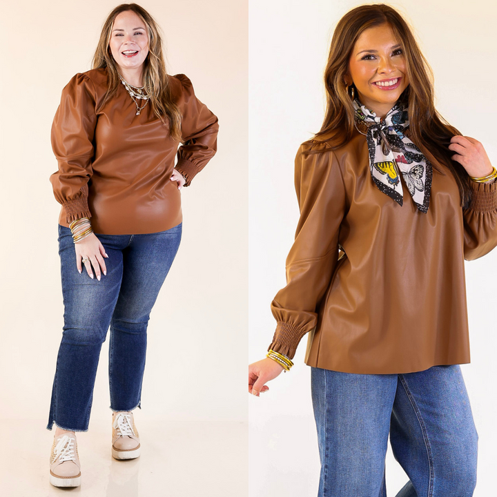 woman wearing a brown faux leather top and blue jeans on a white background.