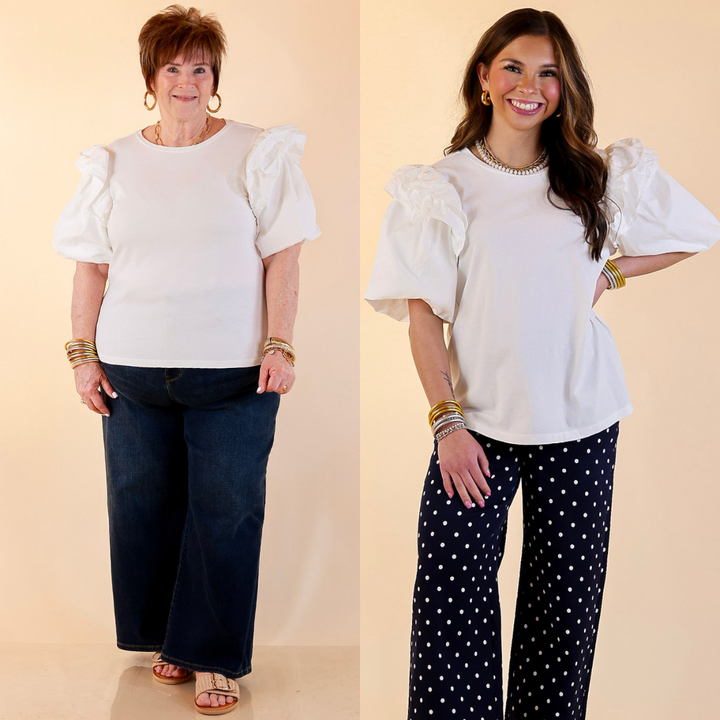 Models are wearing Mud Pie Ruffle Puff Sleeve Knit Top in White with Jeans against a beige backdrop. 