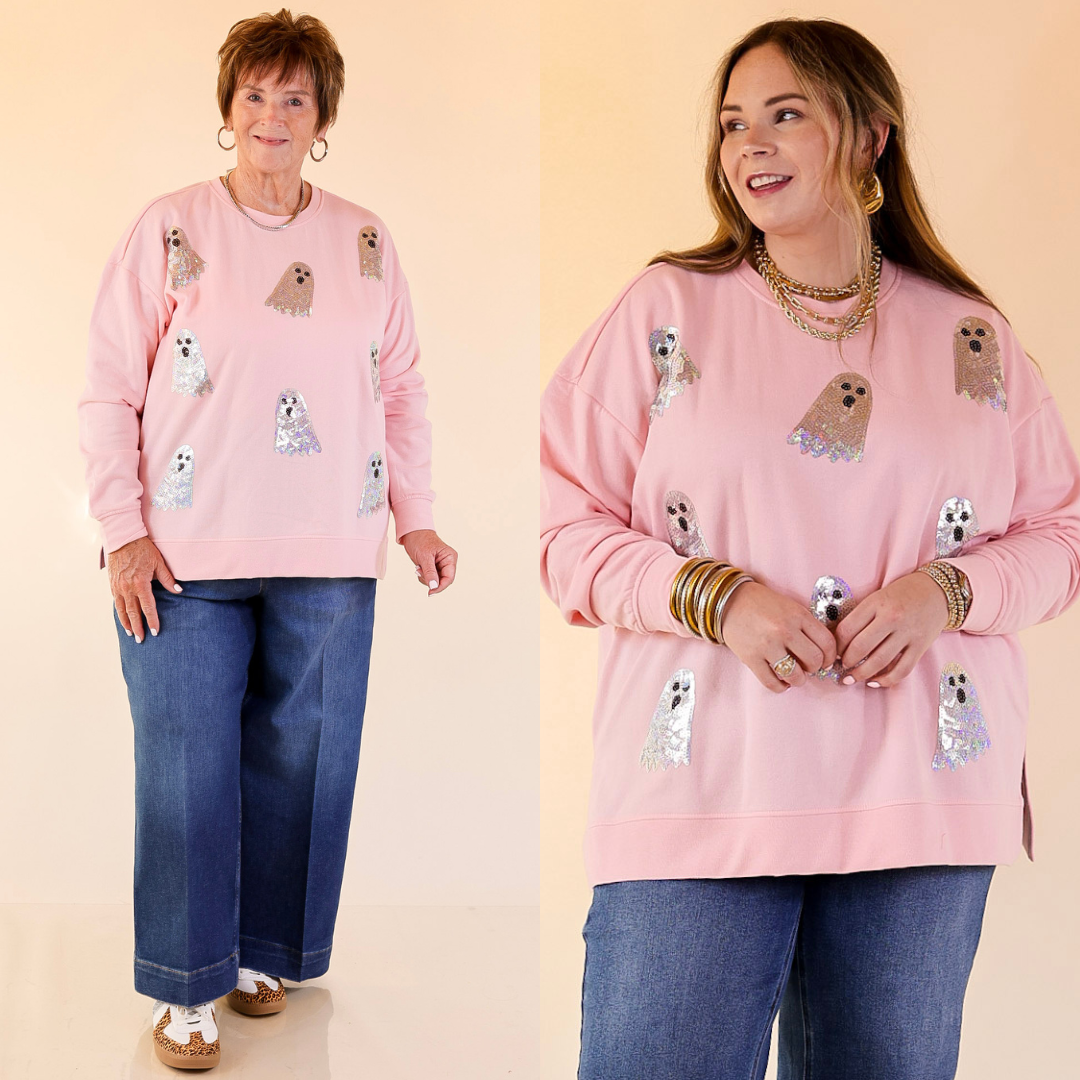 Two people wearing pink sweatshirts with ghost sequin graphics on a beige background