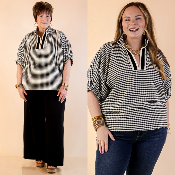 Models are wearing Gingham Plaid Top with Contrast Stripe Trim and Short Dolman Sleeves in Black with jeans against a beige backdrop. 