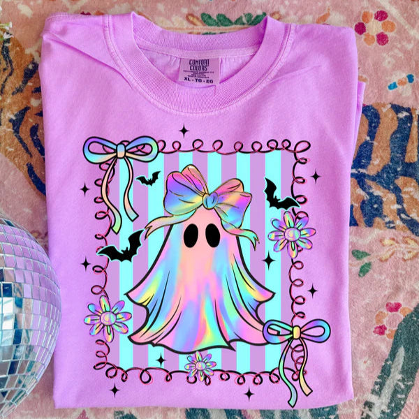 Pink t-shirt with a colorful ghost design on a patterned surface