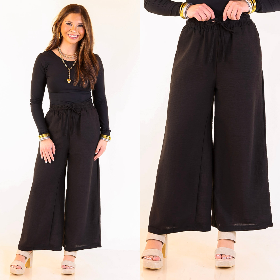 Woman wearing a black cropped woven pant on a white background