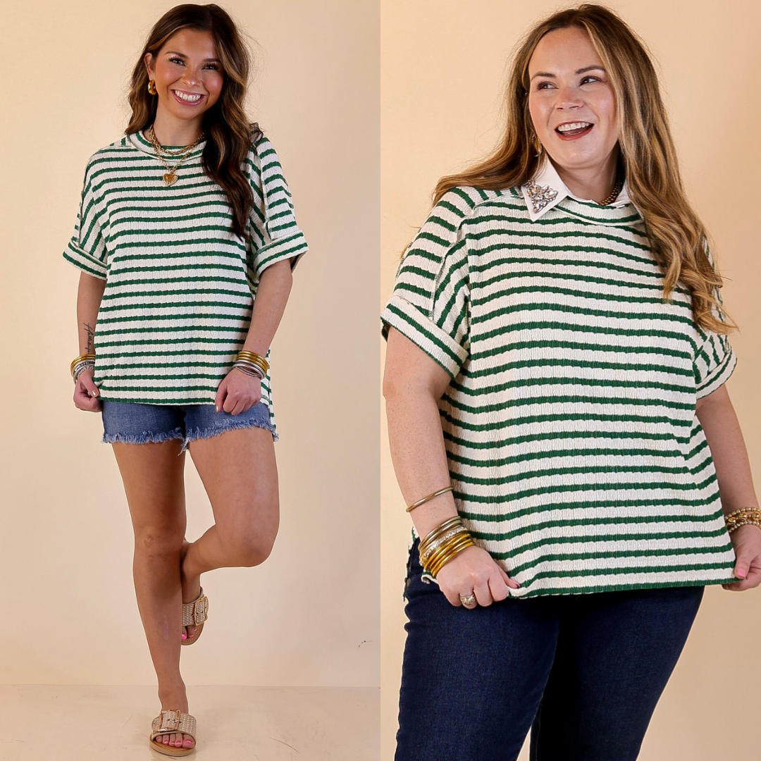 Two women wearing green and white striped tops against a beige background