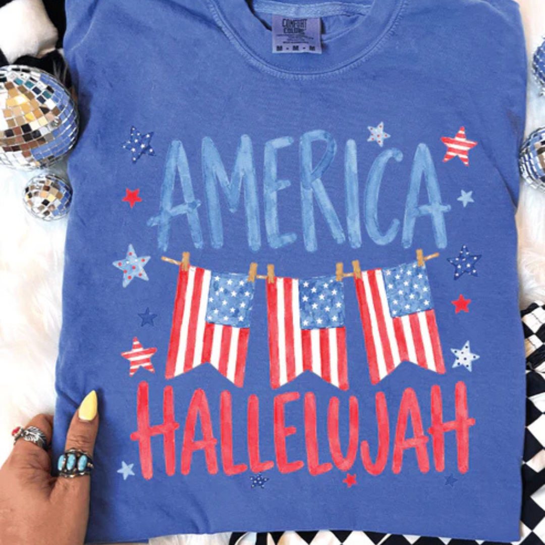Flo blue graphic tee featuring an America Hallelujah design with American flag bunting, patriotic stars, and red, white, and blue lettering.