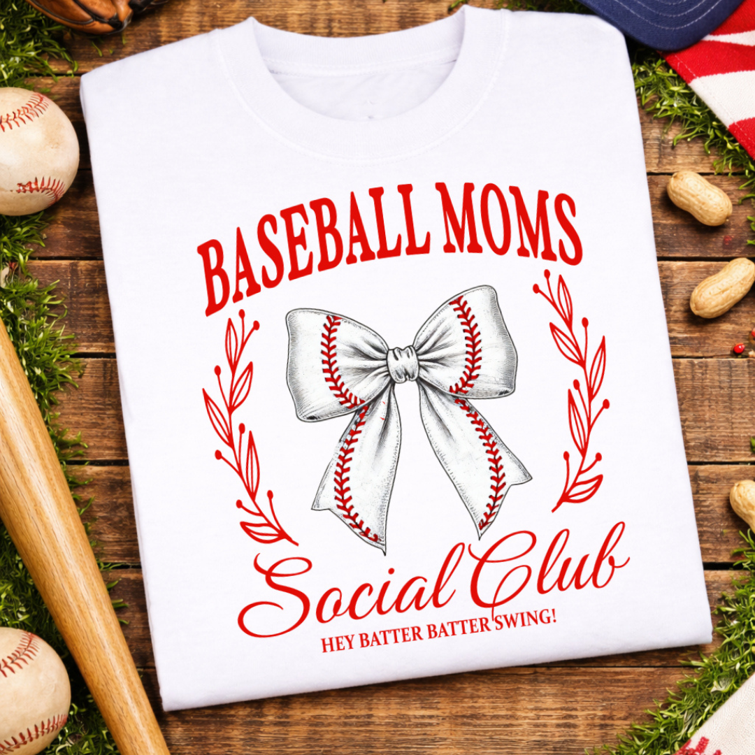 White graphic tee featuring the phrase "Baseball Moms Social Club" with a baseball stitch bow, red botanical accents, and the words "Hey Batter Batter Swing!"