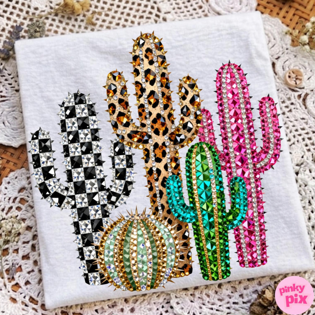 White graphic tee featuring colorful western cactus designs with checkered, leopard, pink, and crystal-inspired details.