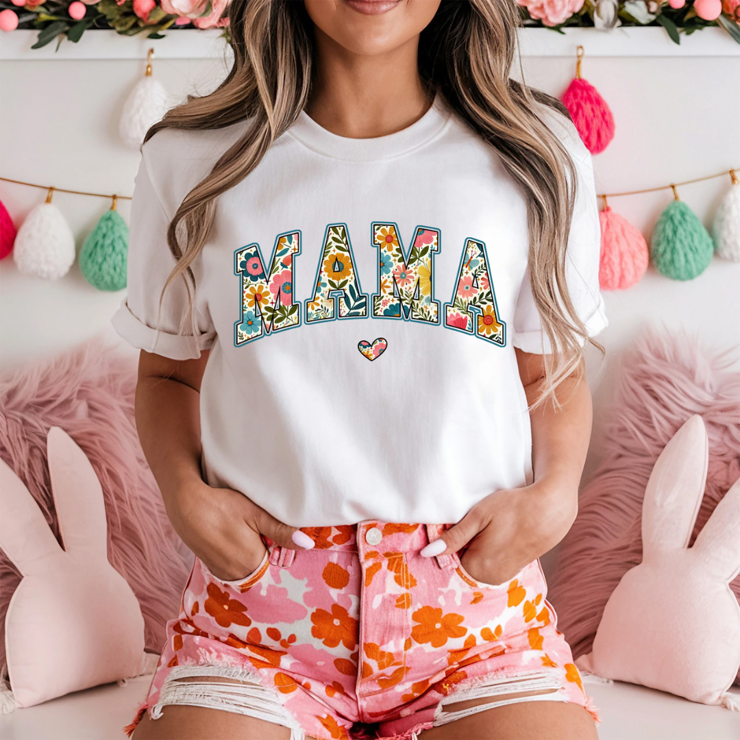 White graphic tee featuring colorful floral MAMA lettering with a coordinating floral heart accent.