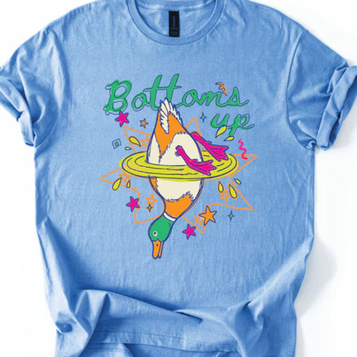 Graphic t-shirt featuring a colorful upside-down mallard duck splashing into water with Bottoms Up text in multiple color options.