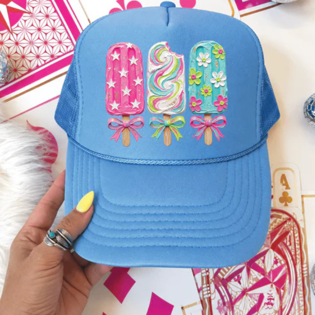 Carolina blue foam trucker hat featuring three colorful decorative popsicles with floral, star, swirl, and bow accents.