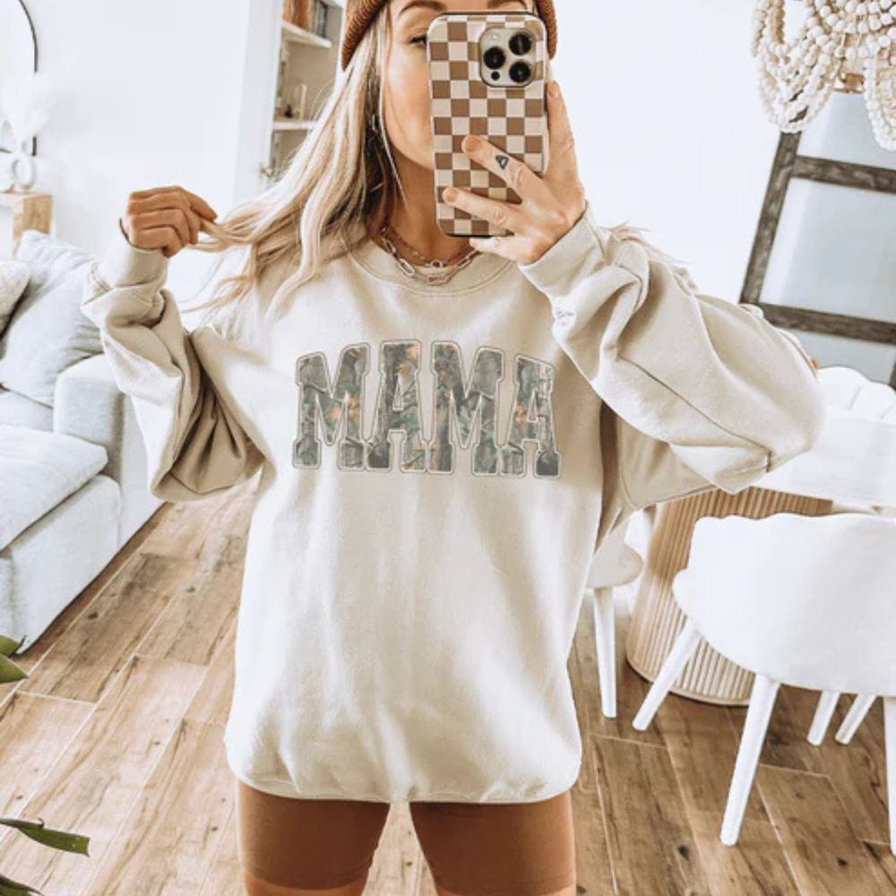 Graphic tee and sweatshirt featuring a bold varsity-style MAMA design with camouflage print lettering.
