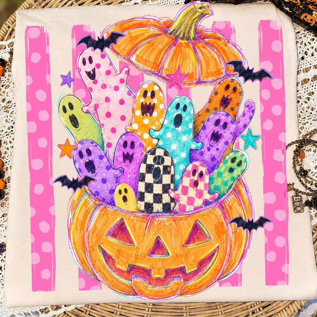 Cream Halloween graphic tee featuring colorful ghosts popping out of a smiling jack-o&