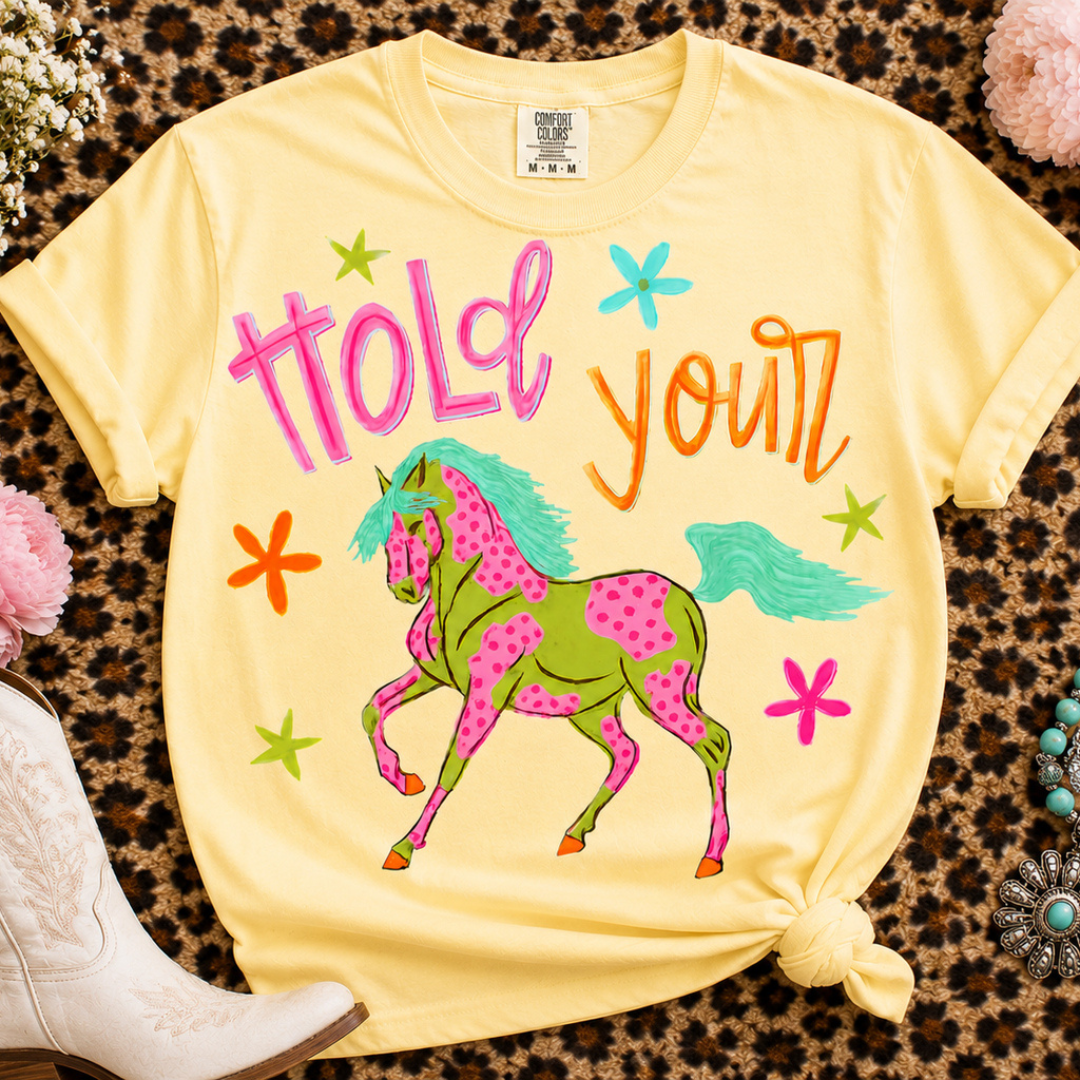 Butter yellow Comfort Colors graphic tee featuring a colorful spotted horse with Hold Your lettering and bright western-inspired artwork.