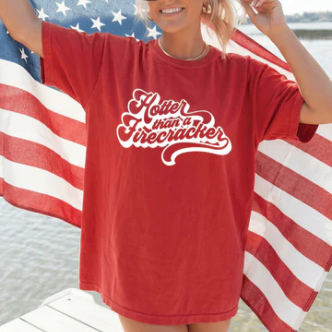 Red Comfort Colors graphic t-shirt featuring Hotter Than a Firecracker retro script design.