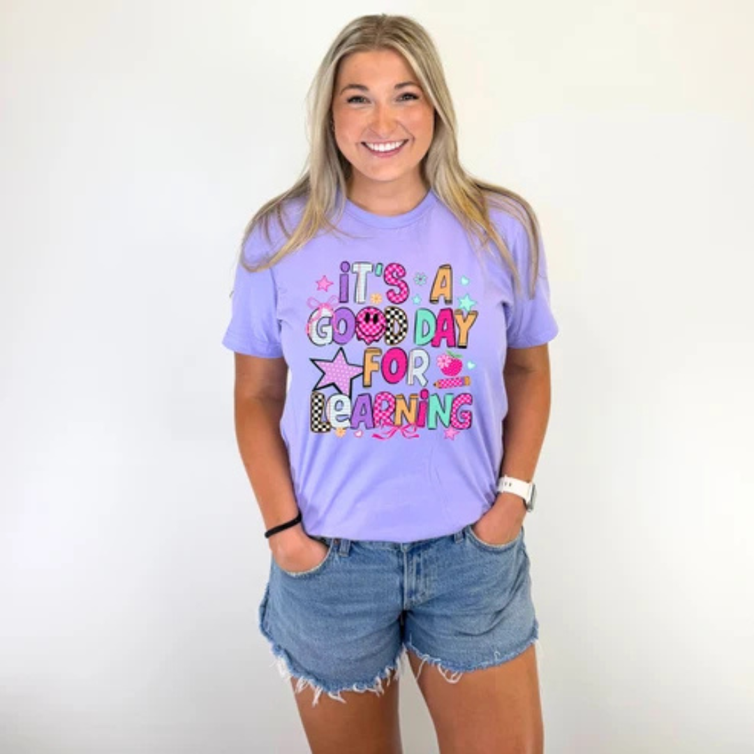 Lavender purple graphic teacher tee featuring colorful "It&