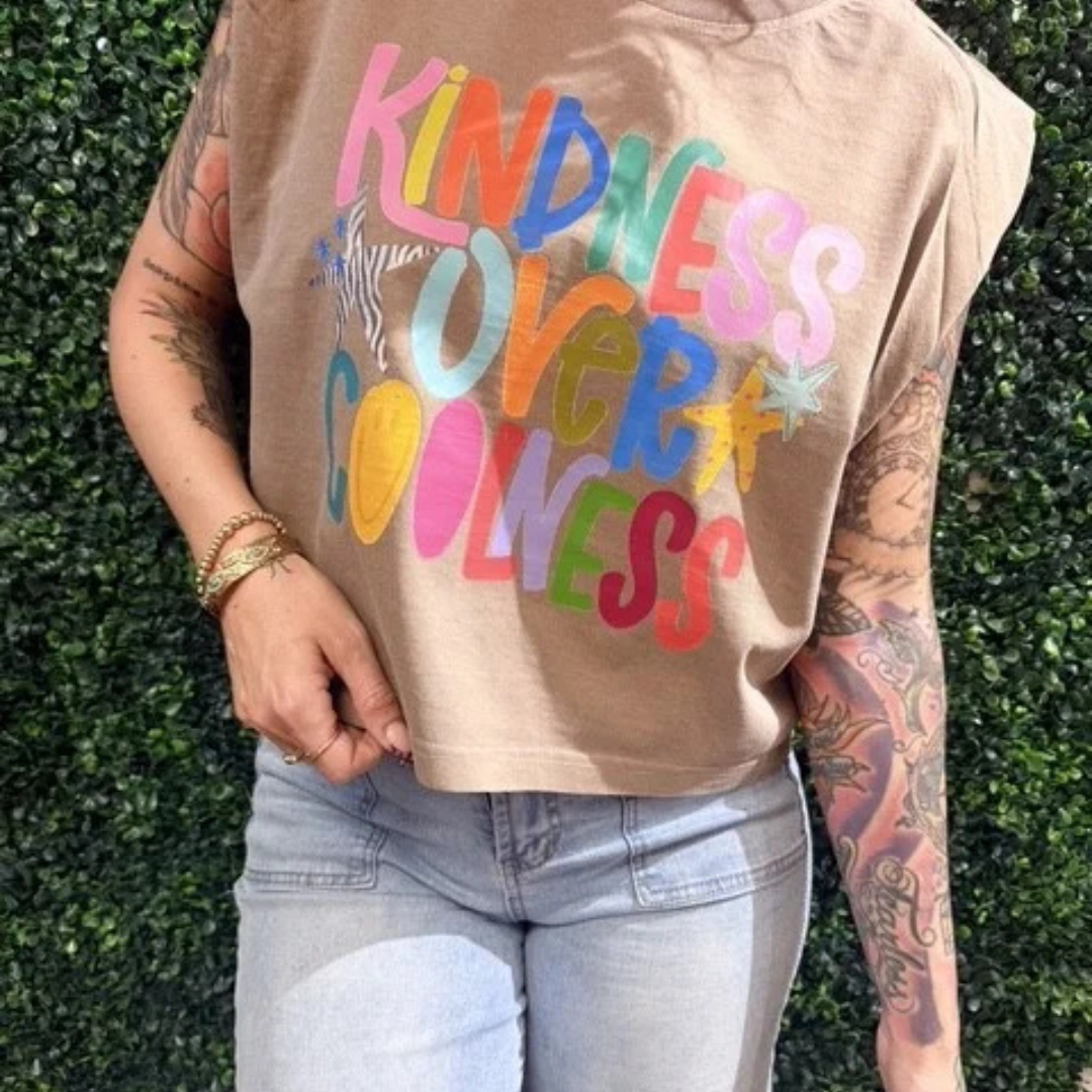 Mocha brown sleeveless graphic tee featuring a colorful "Kindness Over Coolness" rainbow graphic design.