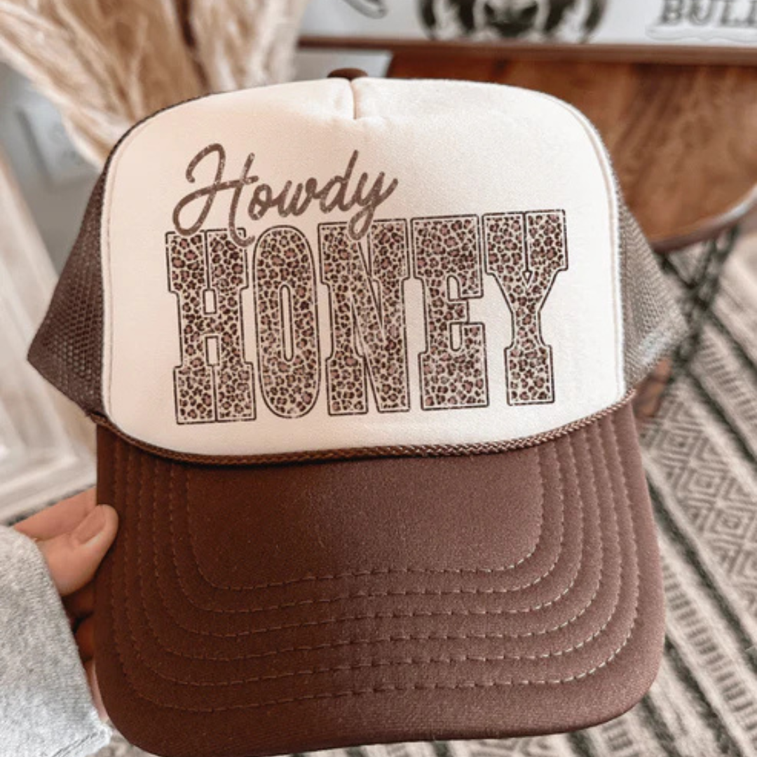 Brown and tan trucker hat featuring a Howdy Honey graphic with trendy leopard print lettering.