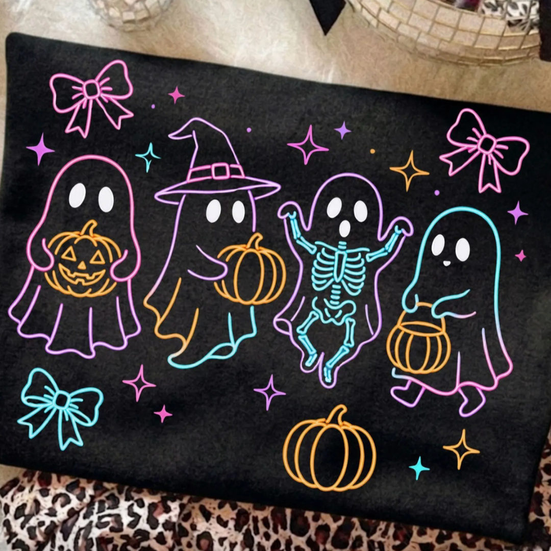 Black Halloween graphic tee featuring colorful neon-style ghosts, a dancing skeleton, pumpkins, bows, stars, and playful spooky season artwork.