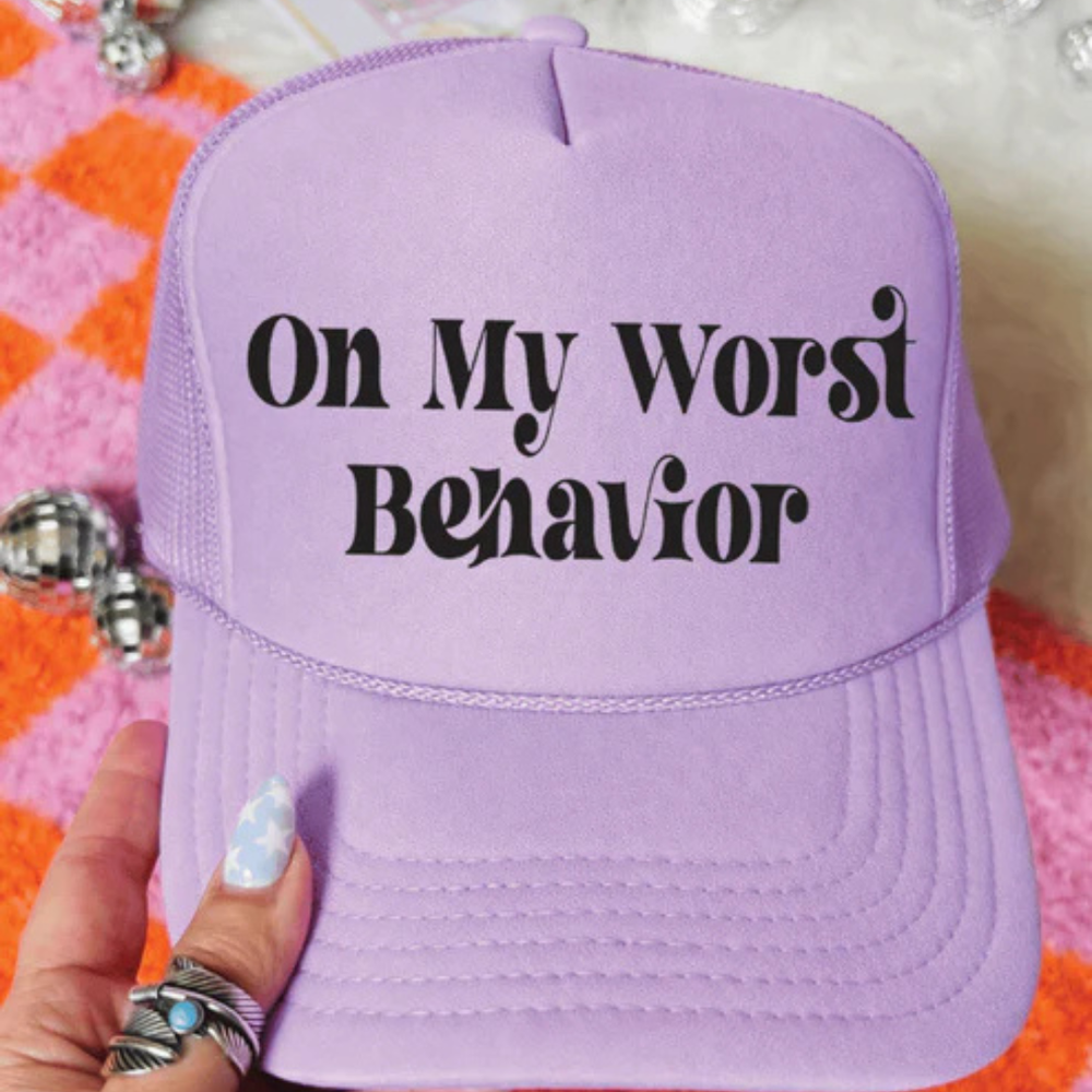 Foam trucker hat available in multiple colors featuring the phrase On My Worst Behavior in a retro-inspired black font.