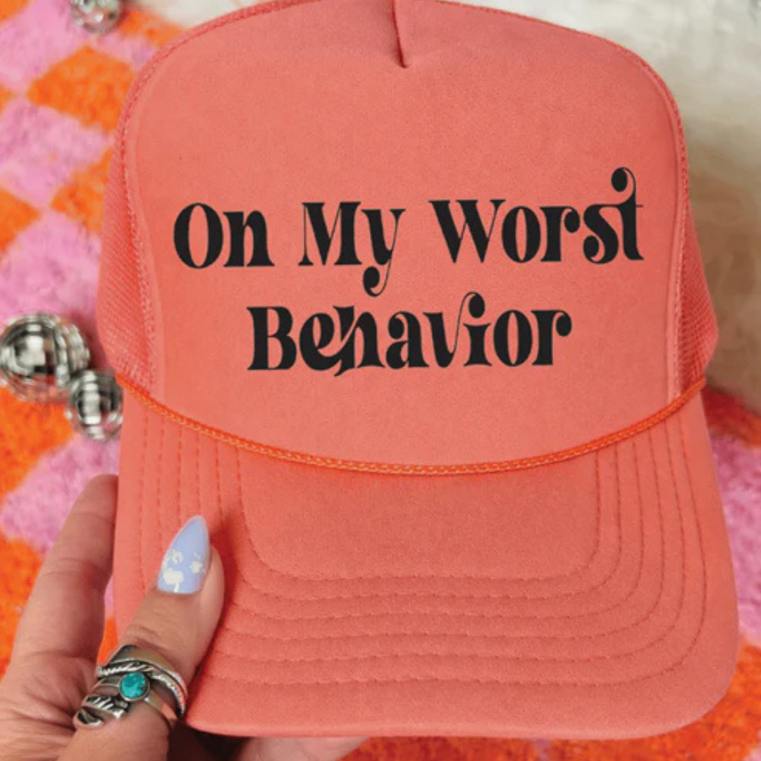 Foam trucker hat available in multiple colors featuring the phrase On My Worst Behavior in a retro-inspired black font.