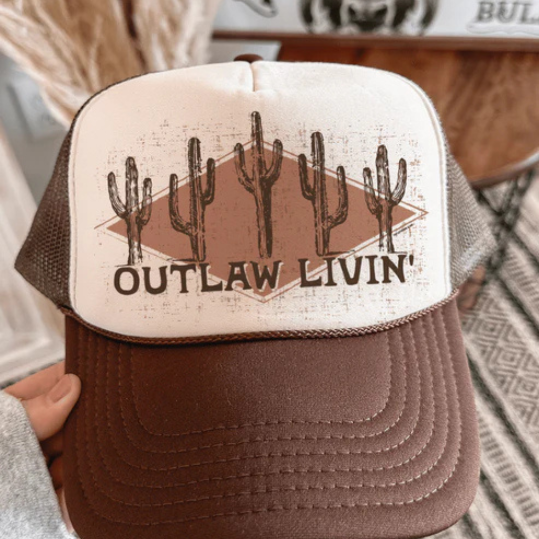 Brown and cream foam trucker hat featuring a vintage western cactus graphic and Outlaw Livin&